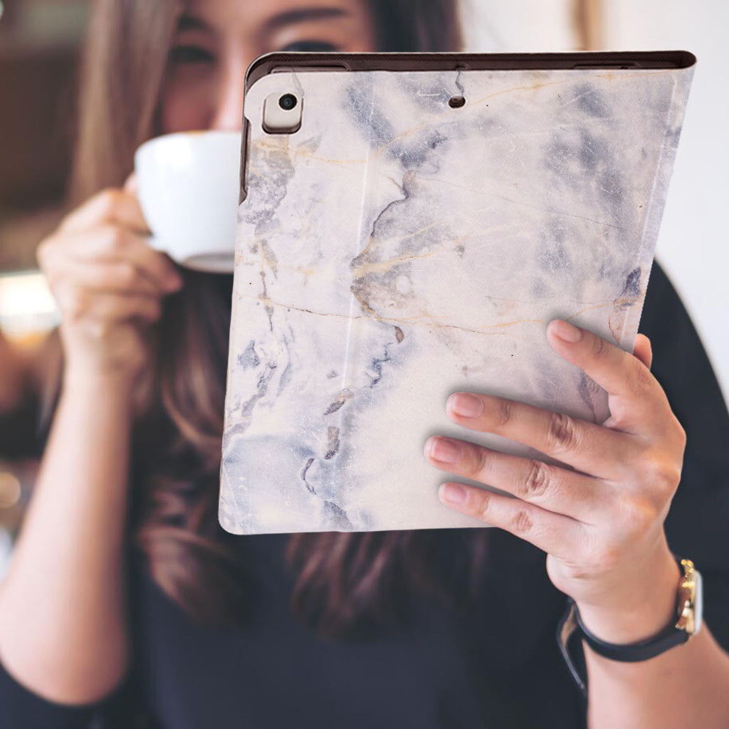 a girl is holding and viewing personalized iPad folio case with Marble design