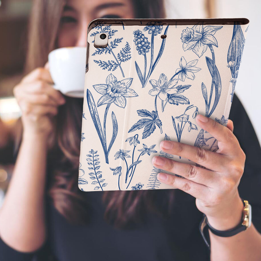 a girl is holding and viewing personalized iPad folio case with Flower design